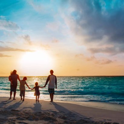 happy family with tree kids walk at sunset tropical beach